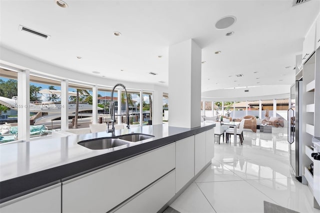 kitchen featuring plenty of natural light, white cabinets, and sink