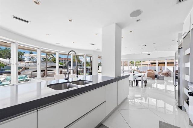 3344 NE 167th St, North Miami Beach, FL 33160 - kitchen with a sink, white cabinetry, modern cabinets, open floor plan, and light tile patterned floors
