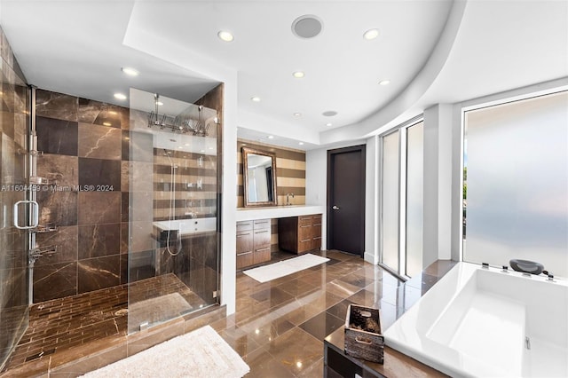 bathroom featuring vanity, a raised ceiling, and a shower with shower door