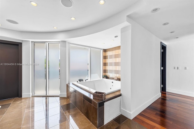 bathroom with wood-type flooring and shower with separate bathtub