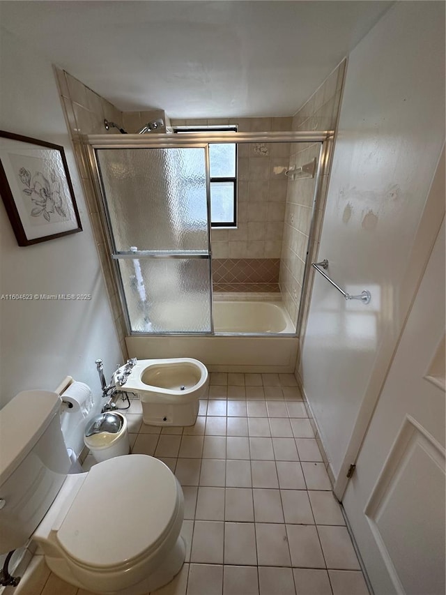 bathroom with a bidet, toilet, combined bath / shower with glass door, and tile patterned flooring