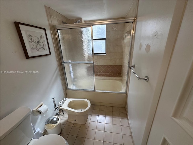 bathroom with bath / shower combo with glass door, tile patterned floors, a bidet, and toilet