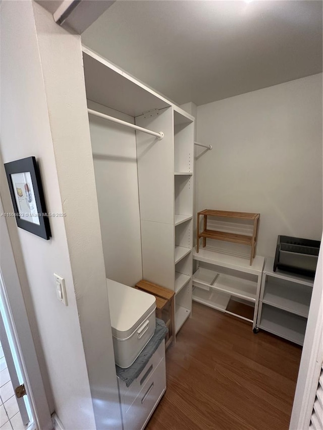 walk in closet with dark wood-type flooring