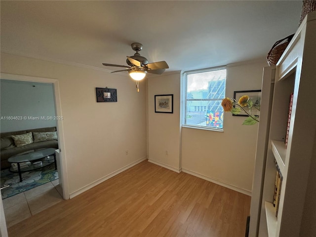 empty room featuring ceiling fan, ornamental molding, and light hardwood / wood-style flooring