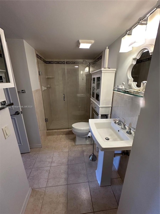 bathroom with a shower with shower door, sink, tile patterned floors, and toilet