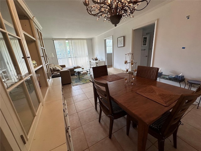 dining area featuring light tile patterned floors, crown molding, and a chandelier