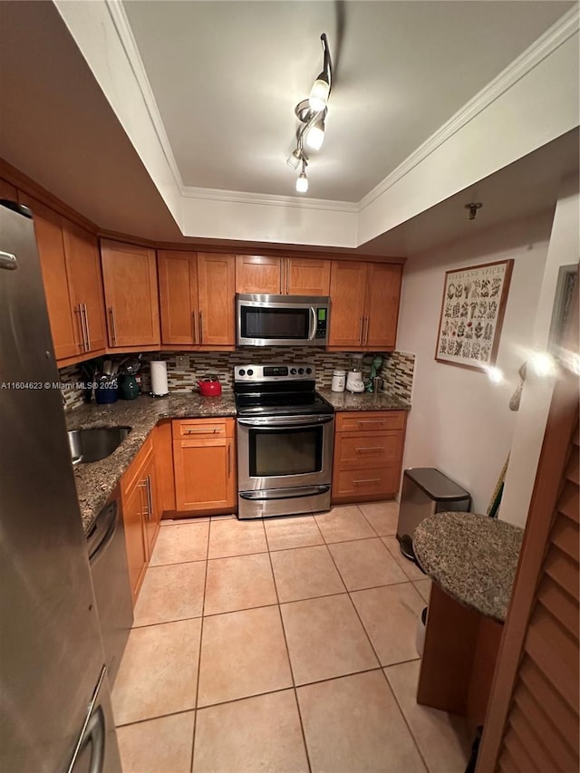 kitchen with sink, appliances with stainless steel finishes, light tile patterned flooring, and a tray ceiling