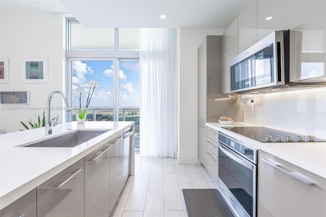 kitchen with sink, light tile flooring, and stainless steel appliances