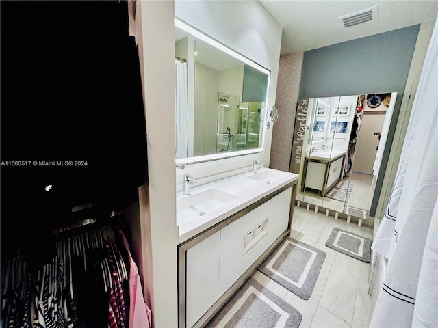 bathroom with dual bowl vanity and tile floors