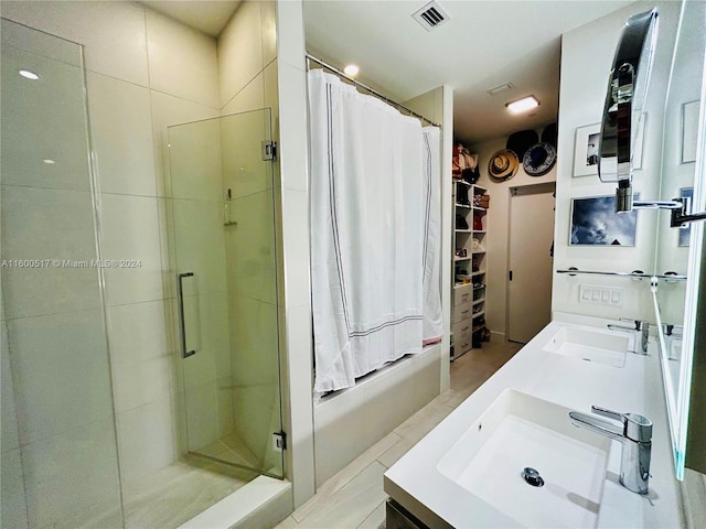 bathroom with tile floors, a shower with door, and double sink vanity