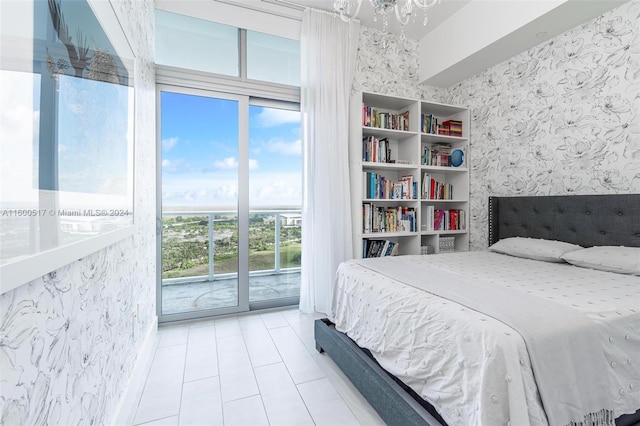 bedroom featuring access to exterior and an inviting chandelier