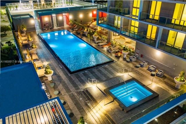 view of swimming pool with a patio area and a hot tub