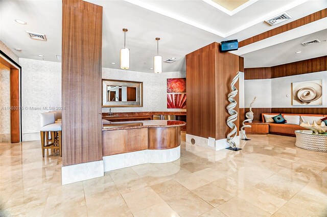 kitchen featuring kitchen peninsula, decorative light fixtures, and light tile floors