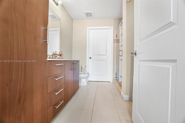 bathroom with tile floors, an enclosed shower, vanity, and toilet