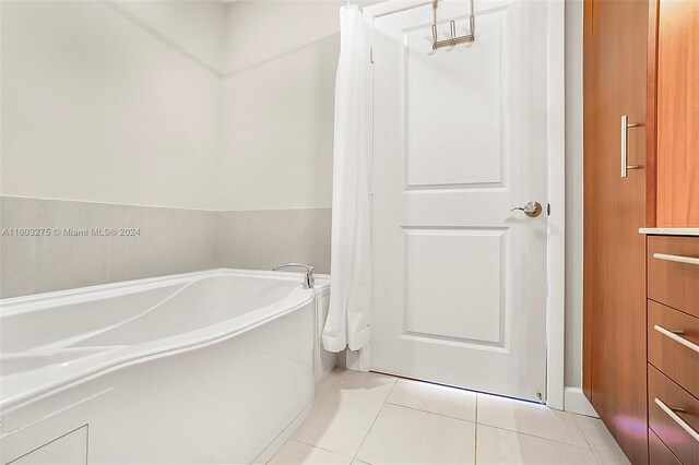 bathroom with tile flooring and a bathing tub