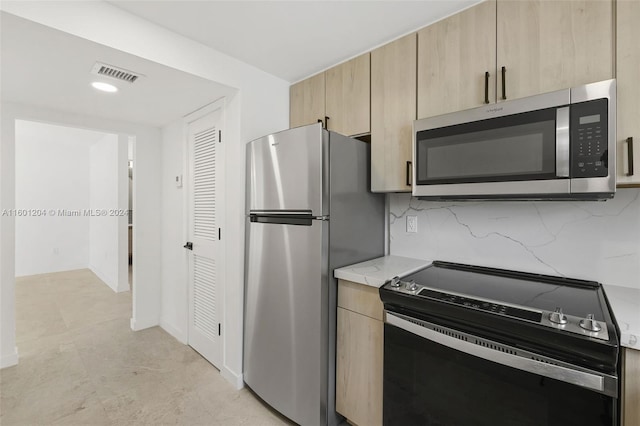 kitchen featuring tasteful backsplash, light brown cabinetry, and stainless steel appliances