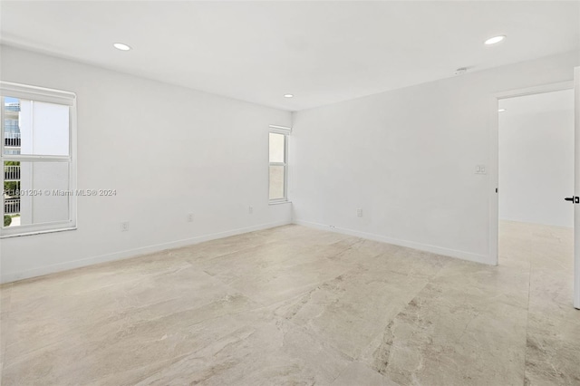 tiled spare room with a healthy amount of sunlight