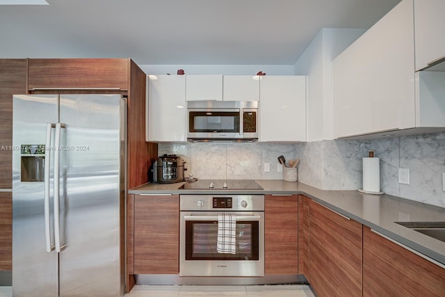 kitchen featuring light tile patterned floors, stainless steel appliances, backsplash, and white cabinets