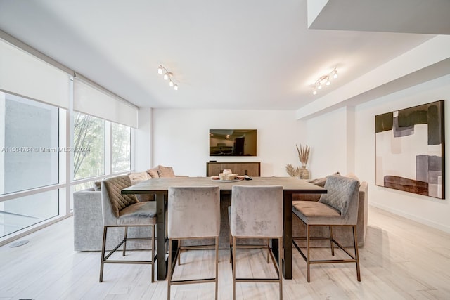 dining room featuring light wood-type flooring and track lighting