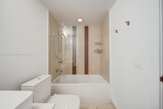 bathroom featuring tile patterned flooring, tiled shower / bath combo, and toilet