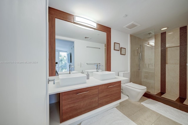 bathroom with double vanity, tile patterned floors, toilet, and an enclosed shower