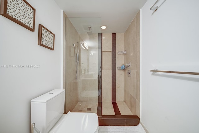 bathroom featuring tile patterned floors, a shower with shower door, and toilet