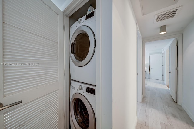 washroom featuring stacked washer and dryer and light wood-type flooring