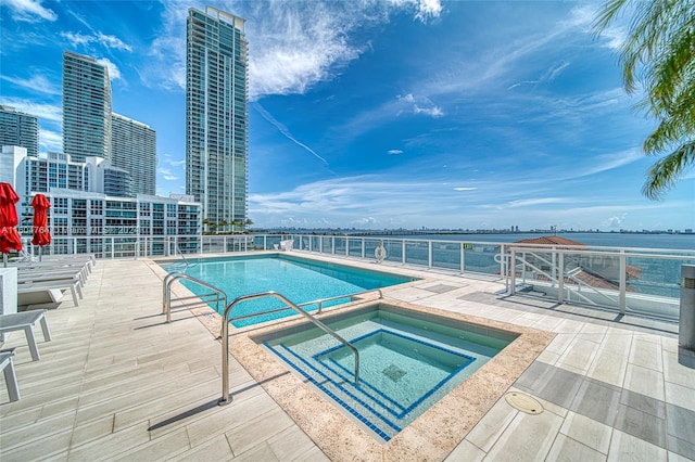 view of swimming pool featuring a community hot tub and a patio