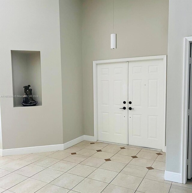 foyer with a towering ceiling and light tile flooring