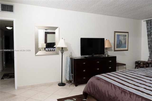 bedroom with a textured ceiling and light tile patterned flooring