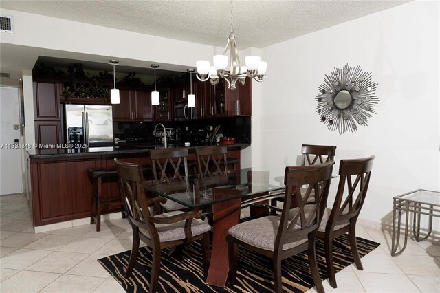 dining space featuring light tile patterned floors, a textured ceiling, and an inviting chandelier