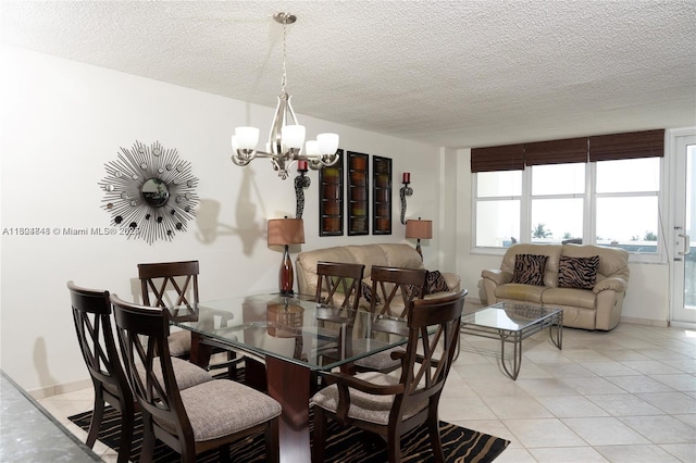 tiled dining room with a textured ceiling and an inviting chandelier