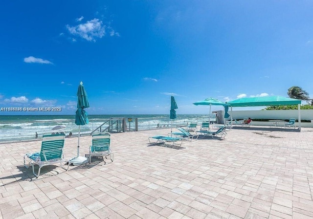 view of patio featuring a beach view and a water view