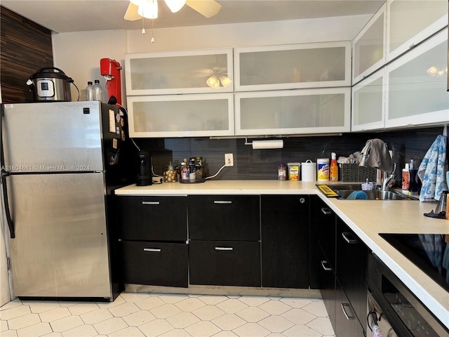 kitchen with backsplash, sink, light tile patterned floors, stainless steel fridge, and ceiling fan