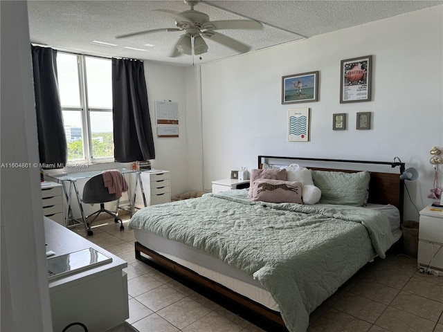 bedroom featuring ceiling fan, a textured ceiling, and light tile patterned floors