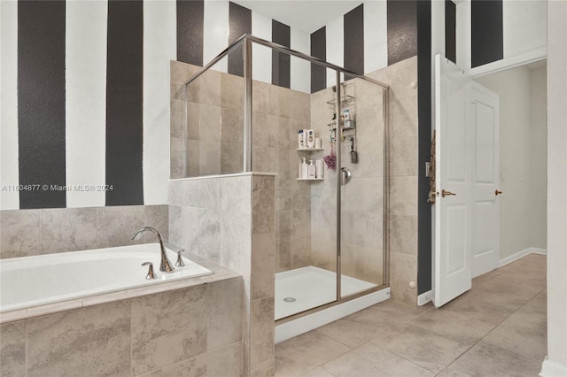 bathroom featuring tile flooring and separate shower and tub