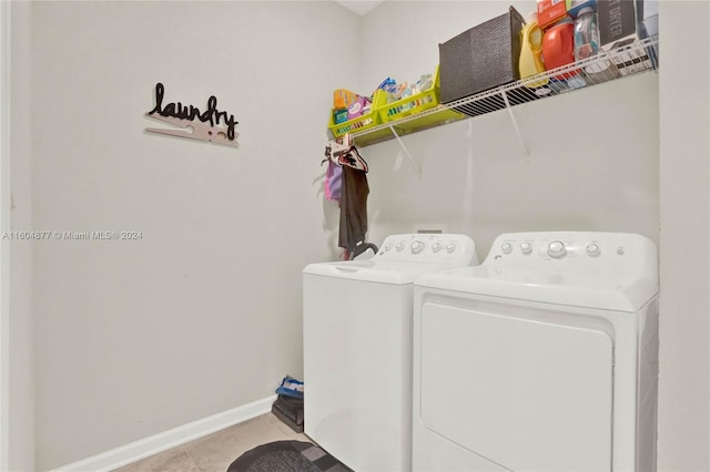 laundry area featuring washer and dryer and light tile floors