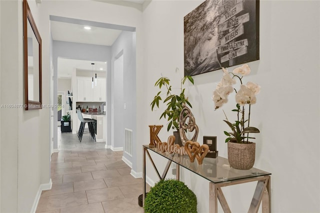 hall featuring light tile flooring