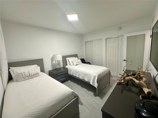 bedroom with multiple closets and hardwood / wood-style floors