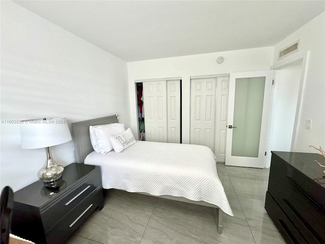 bedroom featuring multiple closets and tile flooring