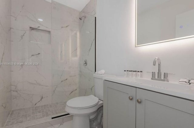 bathroom featuring tiled shower, tile patterned flooring, toilet, and vanity