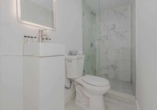 bathroom with tiled shower, vanity, toilet, and tile patterned floors