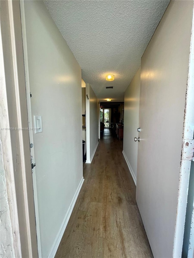 hallway featuring hardwood / wood-style floors and a textured ceiling