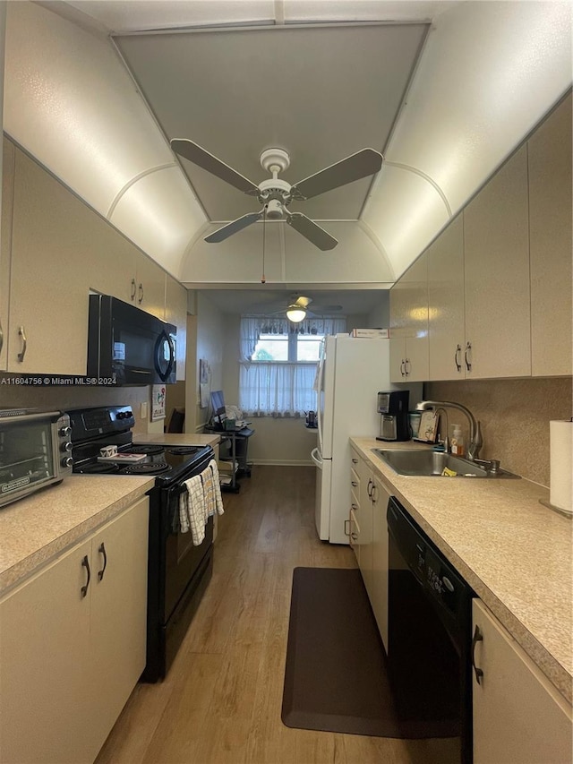 kitchen with sink, black appliances, light hardwood / wood-style floors, and ceiling fan