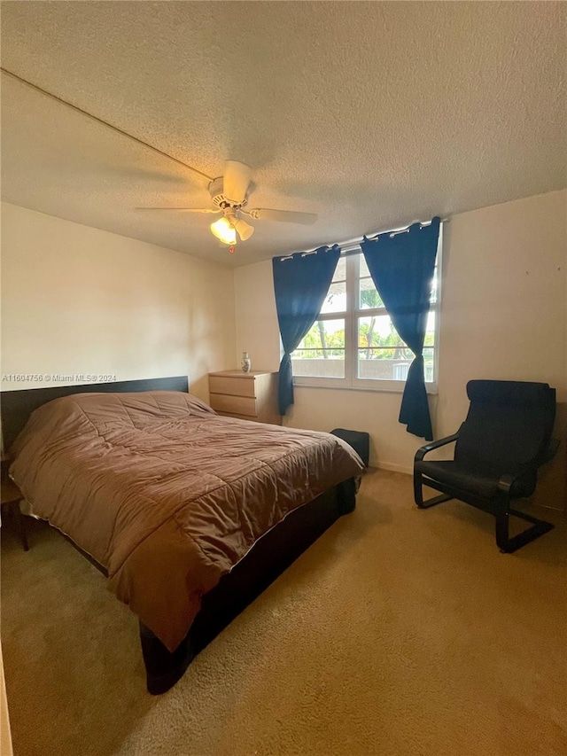 bedroom featuring ceiling fan, a textured ceiling, and carpet flooring