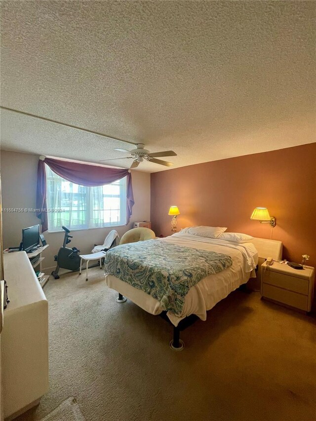 carpeted bedroom with ceiling fan and a textured ceiling