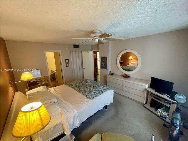 carpeted bedroom featuring ceiling fan and a textured ceiling