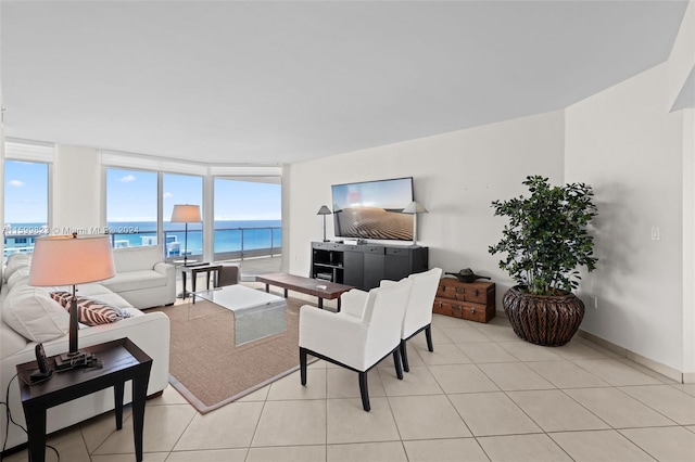 living room with a wealth of natural light, light tile patterned floors, and floor to ceiling windows