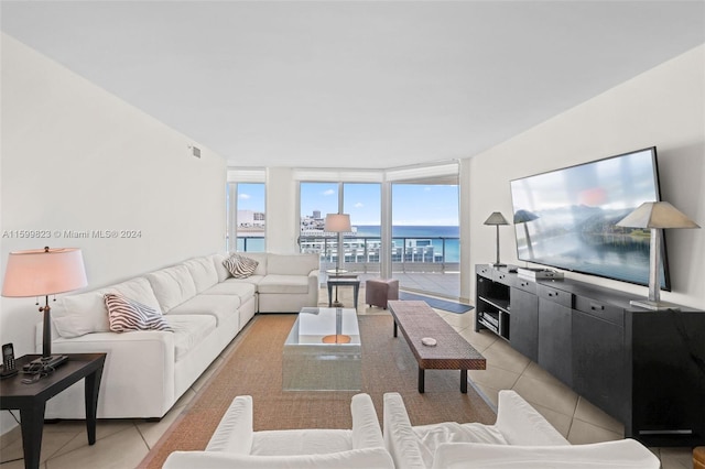 living room with light tile patterned floors and a wall of windows