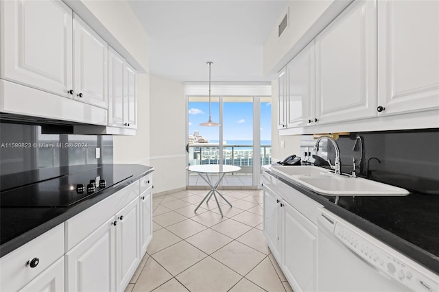 kitchen featuring dishwasher, white cabinets, sink, hanging light fixtures, and light tile patterned floors